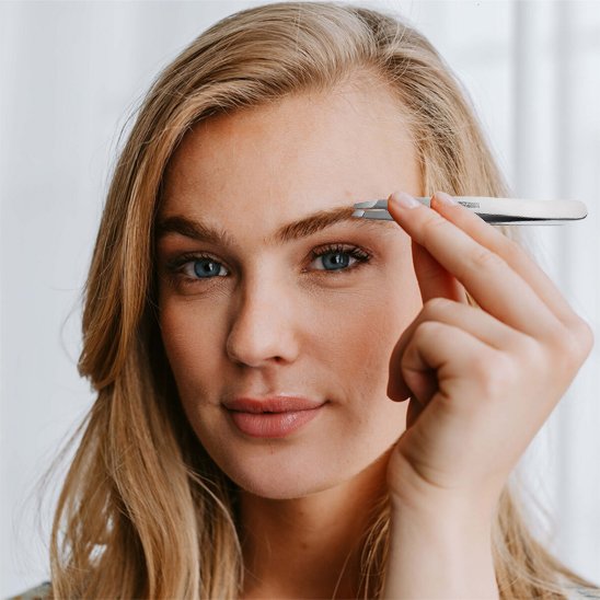 Femme montre une Pince à épiler 