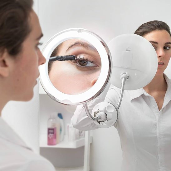 Femme se maquille les yeux devant miroir grossissant