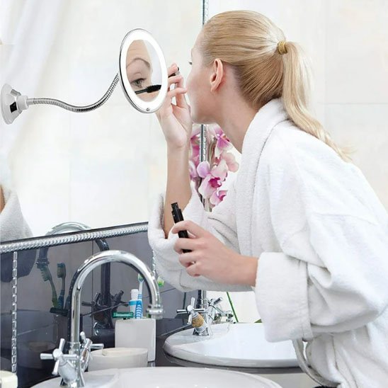 Femme se met du mascara devant miroir grossissant