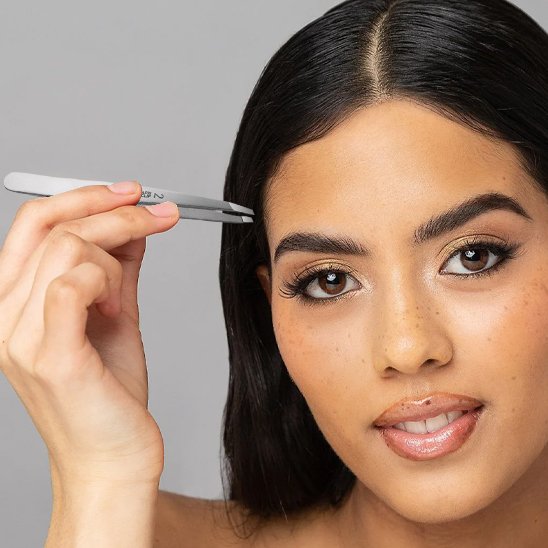 Femme tient une Pince à épiler 